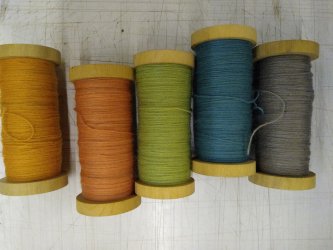 Bobines de fil de laine mérinos pour le tissage d'une écharpe.